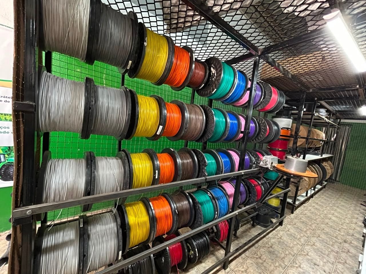 Estante com rolos de fios e cabos de várias bitolas e cores