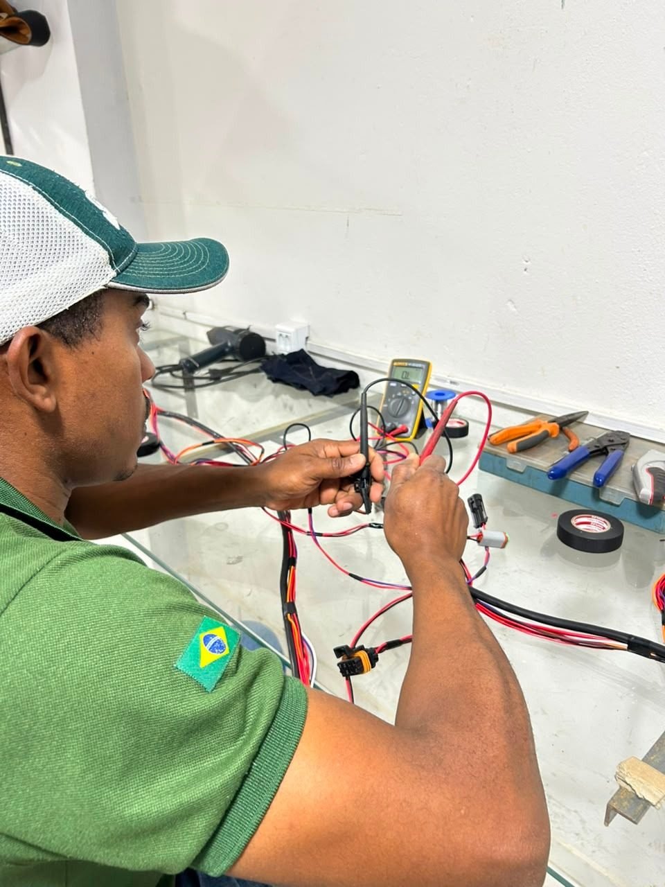 Técnico uniformizado da Connect Máquinas trabalhando em chicote elétrico